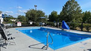 都柏林都伯林贝蒙特套房酒店的一个带椅子的游泳池和蓝色的游泳池