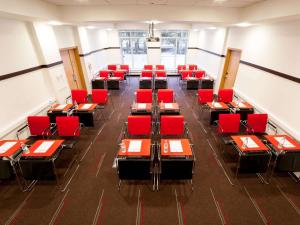 加里宁格勒宜必思加里宁格勒中心酒店的一间用餐室,配有红色的椅子和桌子