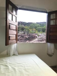 安达拉伊Hostel Portal do Pati的一间卧室,设有窗户,眺望着田野