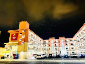 大西洋城Clarion Inn Atlantic City的停车场内停放汽车的大型建筑