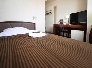 挂川市Royal Inn Kakegawa (Station Hotel 2)的配有一张床和一张书桌的酒店客房