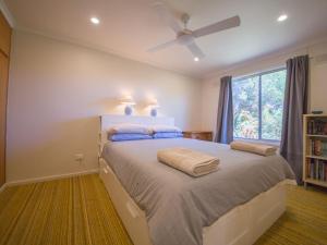 诺曼维尔17 Broadbeach Drive的一间卧室配有一张带吊扇和窗户的床。