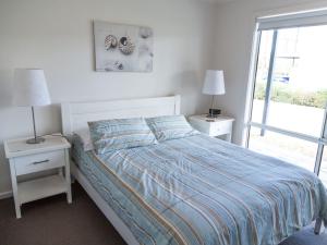 诺曼维尔Shearers Rest 5 Davey Road的一间卧室配有一张带2个床头柜和2盏灯的床。