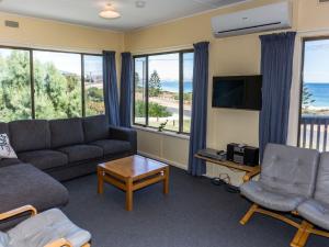 诺曼维尔Sandy Feet 31 Gold Coast Drive的带沙发、电视和窗户的客厅