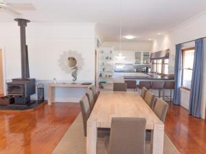 诺曼维尔3 Banksia Court的用餐室以及带桌子和炉灶的厨房。