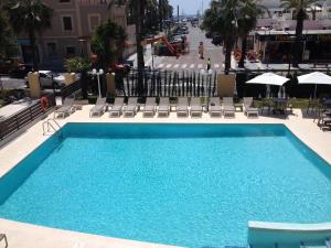 萨洛普拉纳斯酒店的一个带椅子和遮阳伞的大型蓝色游泳池