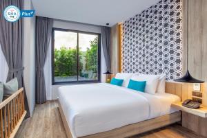查龙The Lake Chalong Hotel SHA Plus的一间卧室设有一张大床和一个窗户。