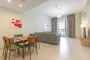 迪拜Grand Stay Holiday Homes Rental的客厅配有桌椅和沙发