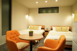 大阪Koti Sopo Universal Bay 3 by Liaison的酒店客房带两张床和一张桌子以及椅子。