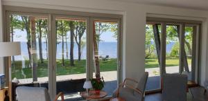 Skulte维德劳奇乡村民宿的客厅设有滑动玻璃门,享有水景