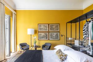佛罗伦萨4F Boutique Hotel Florence的卧室拥有黄色的墙壁,配有一张床和椅子
