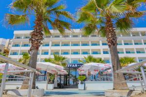 都拉斯Hotel Vivas的棕榈树和遮阳伞的海滩酒店