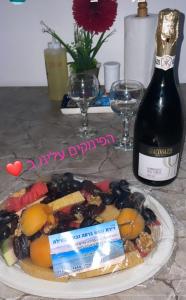 埃拉特דירות נופש וג'קוזי באילת - אילן vip的桌上的一盘食物和一瓶葡萄酒
