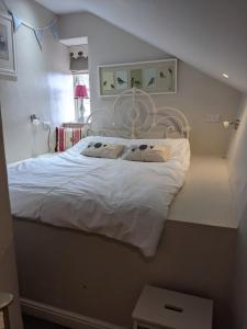 斯基普顿Pinfold Holiday Cottage的卧室配有白色的床和床头板