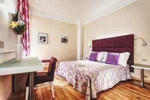 加提欧马里Hotel Spiaggia的一间卧室配有一张床、一张桌子和一张书桌