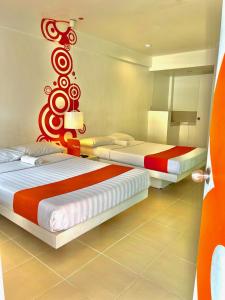 麦克坦Islands Stay Hotels Mactan的红色和白色的客房内的两张床