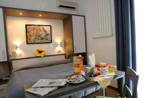 瓦拉泽潘塔贝拉酒店的酒店客房,配有床和餐桌,上面有食物