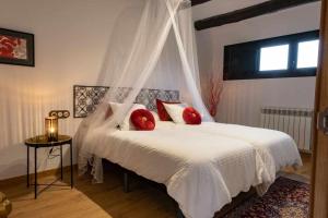 MaldáCa la Cinta de Maldà的卧室配有带红色枕头的白色床