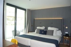 马贝拉Hotel Lima - Adults Recommended的一间卧室设有一张大床和大窗户