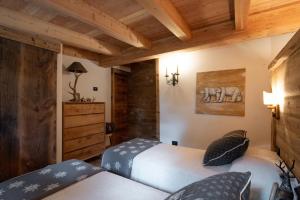 坎皮泰洛迪法萨Dolomiti Chalet degli Abeti的配有木天花板的客房设有两张床。
