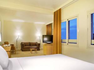十月六日城诺富特开罗酒店的酒店客房配有床、沙发和电视。