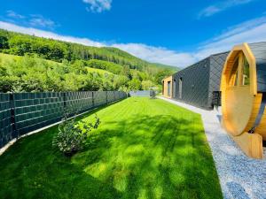 TraisenVoralpen Lodge - Ferienhaus mit Gym, Sauna & Hot Tub的后院设有围栏和绿色庭院