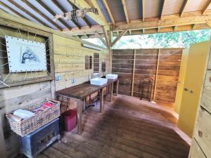 米奥La Wigwam Rouge du Domaine du Pas de l'âne的小木屋内带桌子和两个水槽的木制客房