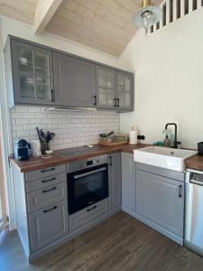 TuraidaVizbules的厨房配有灰色橱柜、水槽和炉灶。