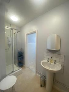 曼斯利Coastal Corner的白色的浴室设有水槽和淋浴。