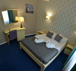 敖德萨Hotel Ajur的两个天鹅坐在酒店房间的床边
