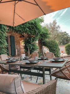 巴代尔纳La Vita Bella Villa的庭院里配有桌椅和遮阳伞