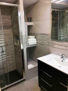 加瓦Apartment La Gavina Beach Barcelona Airport的带淋浴、盥洗盆和镜子的浴室