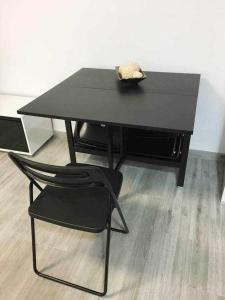 加瓦Apartment La Gavina Beach Barcelona Airport的一张黑桌和一张黑椅子