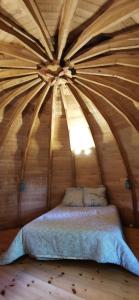 Saint-Aubin-le-Cloudcamping de la chagnée的木天花板的客房内的一张床位