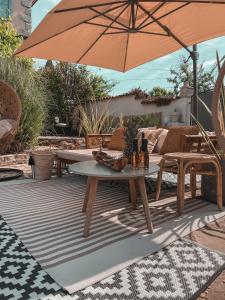 巴代尔纳La Vita Bella Villa的一个带桌子和遮阳伞的庭院