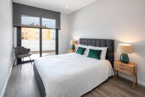 波尔蒂芒Apartment Confort 404的卧室配有带绿色枕头的大型白色床