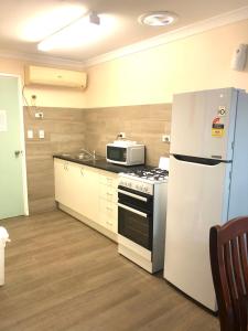 德纳姆海湾度假屋的厨房配有白色冰箱和微波炉