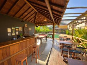 伊塔卡雷Pousada Villa Dos Sonhos的户外酒吧设有木桌和椅子