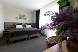 斯伽尔达艾则瑞温泉酒店的一间卧室设有一张床和一个紫色花窗