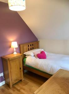 莱特弗拉克Red Deer Cosy Apartment in Letterfrack Connemara的一间卧室,床上有粉红色的动物