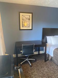 格林斯伯勒锦绣酒店 - 格林斯博罗机场的一张桌子,位于酒店的房间,配有一张床和椅子