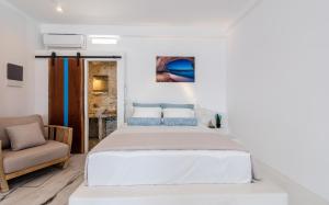 KlimaThe Colourful Land Milos的白色卧室配有床和椅子