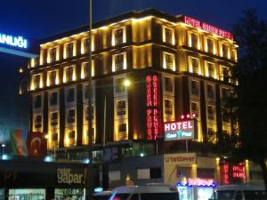 伯萨绿色布鲁萨酒店的建筑的侧面有 ⁇ 虹灯标志