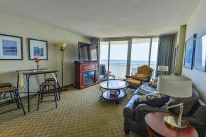 默特尔比奇Deluxe Ocean front One Bedroom suite in Sandy Beach Resort的客厅配有沙发和带壁炉的桌子