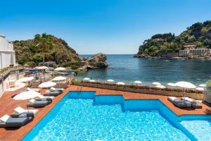 陶尔米纳Mazzarò Sea Palace - The Leading Hotels of the World的一个带椅子的游泳池,享有海景