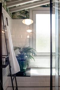 柯米拉斯Apartamentos Boutique Fuente Real的一间设有盆栽和窗户的浴室