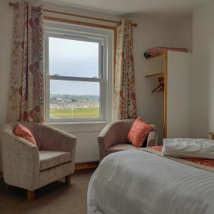 布德林克塞得旅馆的一间卧室配有一张床、两把椅子和一个窗户
