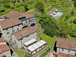 ComanoAgriturismo Casa Turchetti的享有带游泳池的古老建筑的空中景致