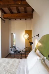 MusignanoIl Poggio di Musignano的卧室配有一张床和一张桌子及椅子