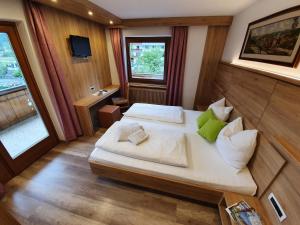 瓦尔奥纳的圣乔凡尼塔纳霍夫乡村民宿的一间卧室配有一张带白色床单和绿色枕头的大床。